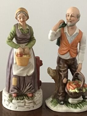 A pair of vintage porcelain figurines of an elderly farming couple